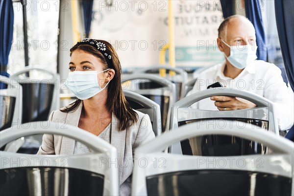 Travelers wearing protective masks commuting by public bus