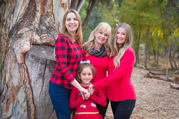 Beautiful mother with young adult daughters and mixed-race granddaughter portrait outdoors