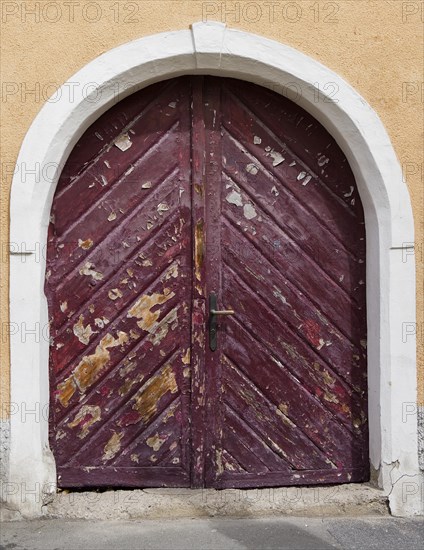 Hausfassade mit alter verwitterter Haustuer mit Rundbogen