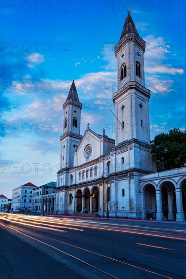 St. Ludwig's Church Ludwigskirche in the evening. Car Light Traces motion blur because of long exposure. Munich