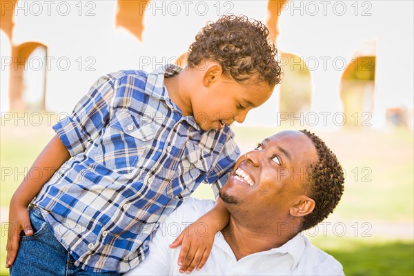 Happy african american father and mixed-race son playing at the park