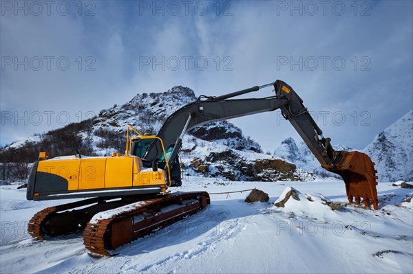 Old excavator with excavator bucket in winter