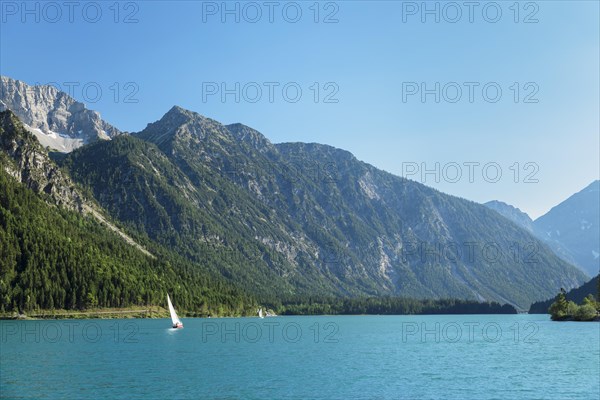 Sailing boat in summer on the Plansee lake near Reutte