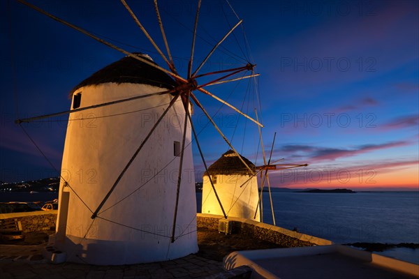 Scenic view of famous Mykonos Chora town windmills. Traditional greek windmills on Mykonos island illuminated in the evening