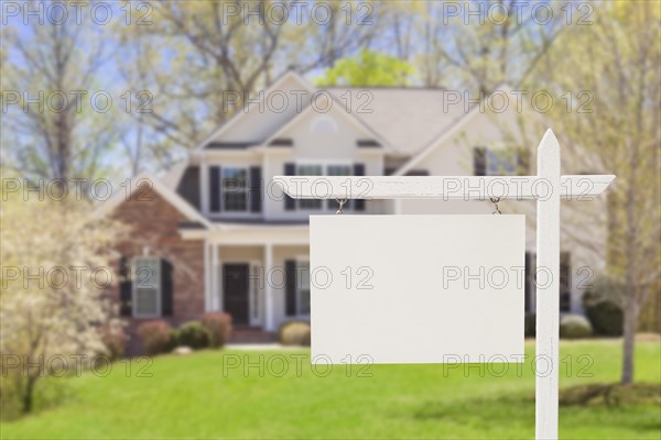 Blank real estate sign in front of beautiful new house