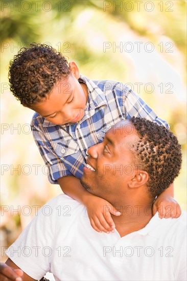 Happy african american father and mixed-race son playing at the park