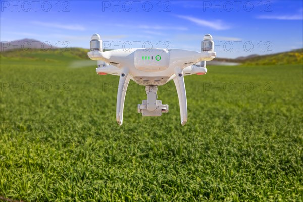 Drone unmanned aircraft flying and gathering data over country farmland