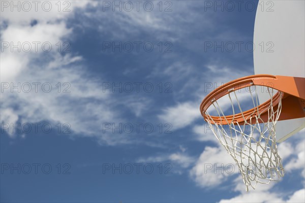 Abstract of community basketball hoop and net against blue sky