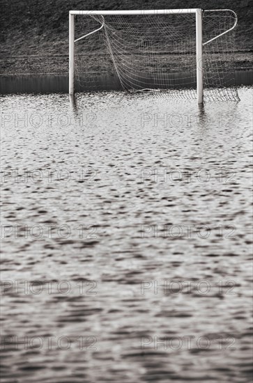 Fussballplatz mit Fussballtor steht unter Wasser