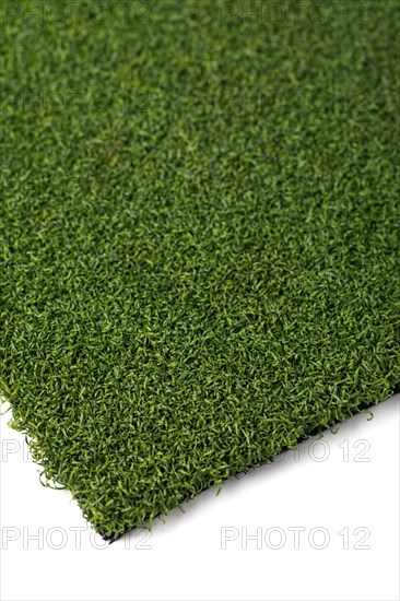 Section of artificial turf grass on white background