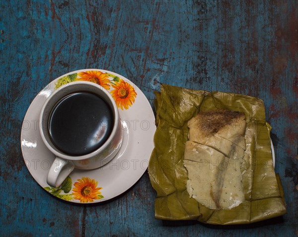 Stuffed tamale served on wooden table