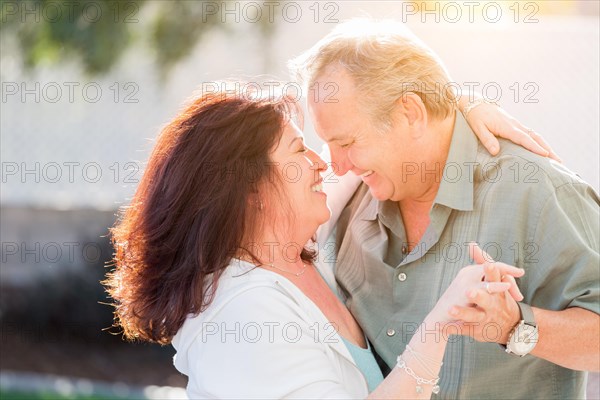 Happy middle aged couple enjoy A romantic slow dance outside