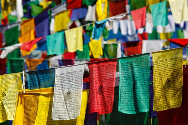 Buddhist prayer flags lungta with Om Mani Padme Hum Buddhist mantra prayer meaning Praise to the Jewel in the Lotus on kora around Tsuglagkhang complex