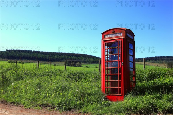Old red telephone box in the countryside