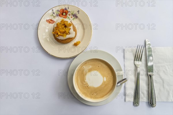 Top view of a latte and an orange cupcake on vintage crockery