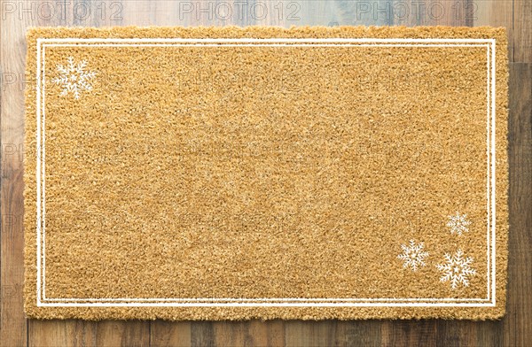 Blank holiday welcome mat with snow flakes on wood floor background