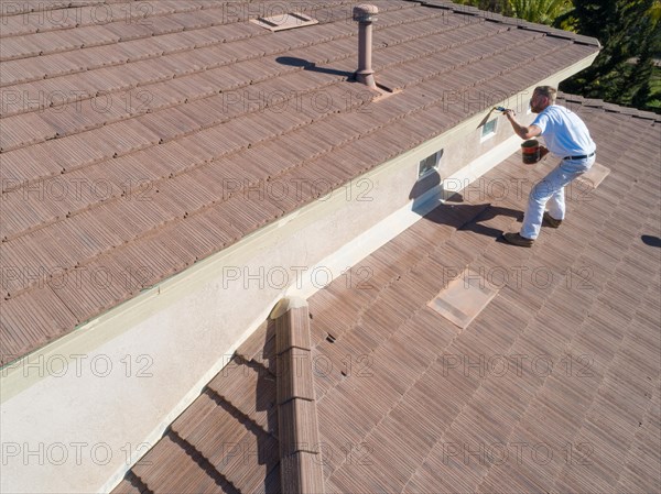 Professional painter using A brush to paint house facade