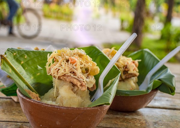 Vigoron with leaves served on a wooden table