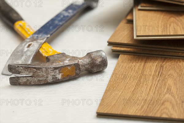 Worn hammer and pry bar with laminate flooring abstract