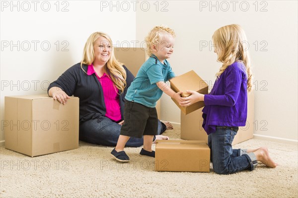 Happy young family in empty room with moving boxes