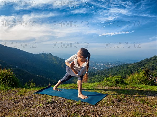 Sporty fit woman practices Ashtanga Vinyasa yoga asana Utthita Parsvakonasana varitation