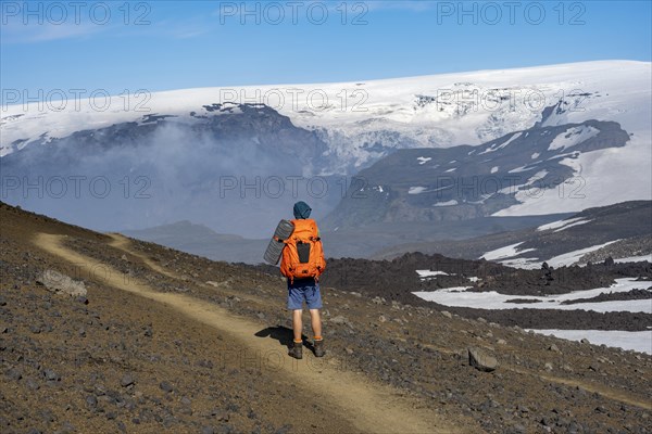 Hikers on trail through volcanic landscape
