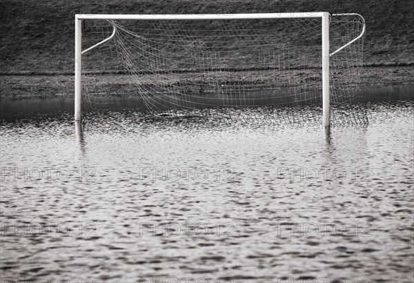 Fussballplatz mit Fussballtor steht unter Wasser