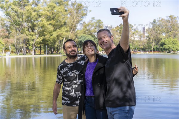 Group of friends of different ages taking a selfie in a lake. Happy expressions. Copy space