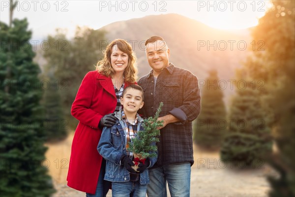 mixed-race family outdoors at christmas tree farm