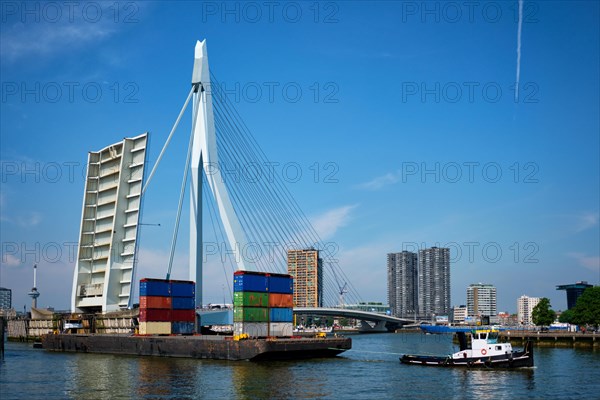 Tug boat towing barge with containers under open bascule part of Erasmusbrug bridge in Nieuwe Maas river. Rotterdam