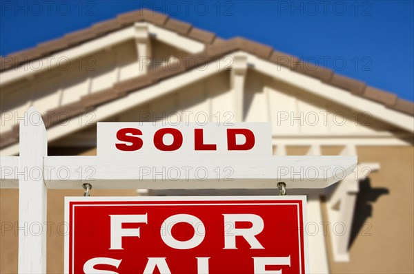 Sold home for sale real estate sign and house