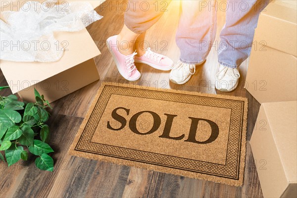 Man and woman standing near sold welcome mat