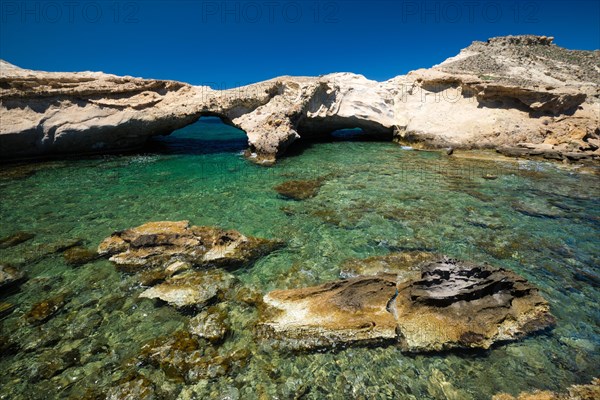 The beach of Agios Konstantinos with crystal clear turquoise water and rock formations in Milos island