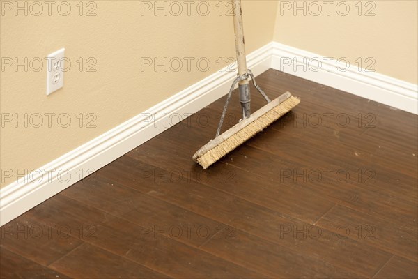 Push broom on a newly installed laminate floor and new baseboards