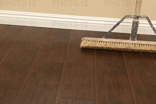 Push broom on a newly installed laminate floor and new baseboards