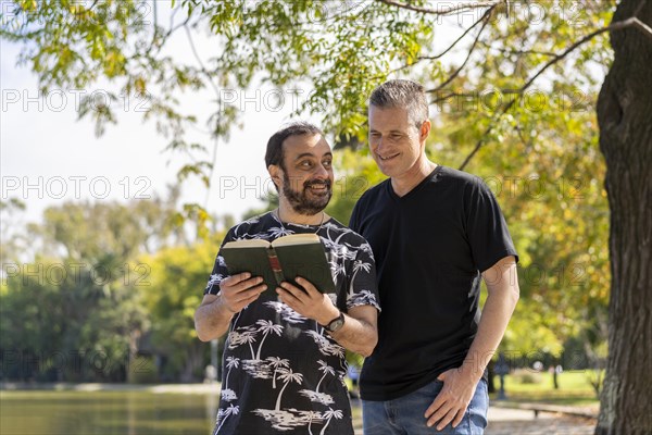 Couple of mature men reading in a lake