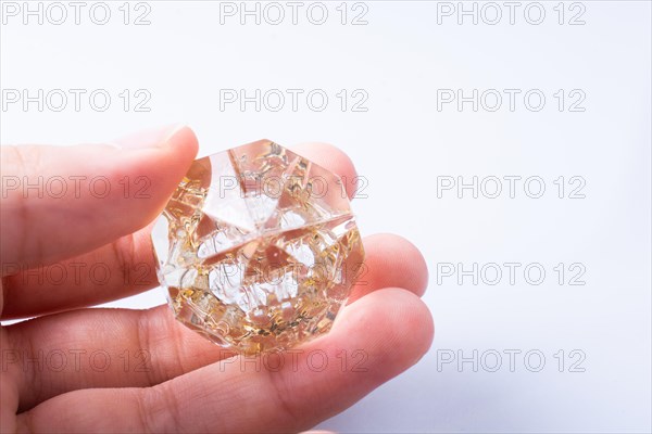 Hand holding a transparent diamond on a white background