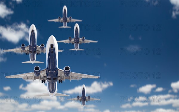 Bottom view of several passenger airplanes flying in the blue sky