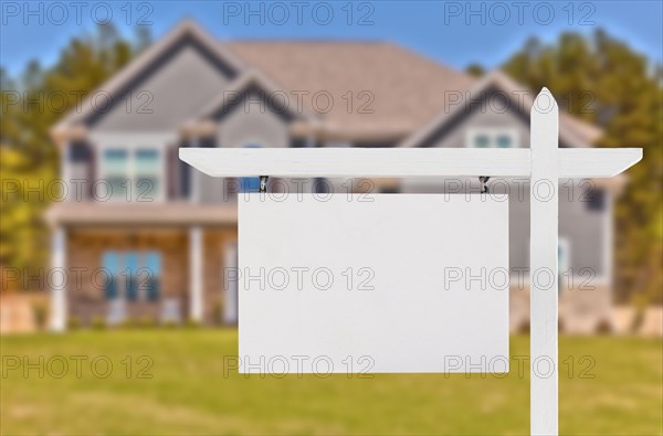 Blank real estate sign in front of beautiful new house