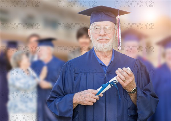 Proud senior man in hat and gown at outdoor graduation ceremony