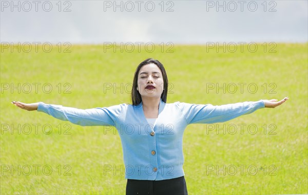 A girl spreading her arms in the field