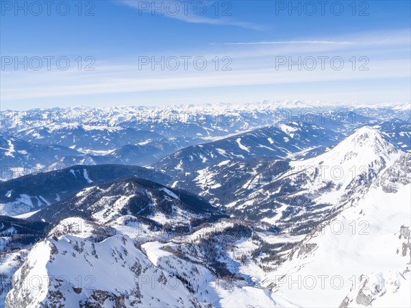 Blauer Himmel ueber Winterlandschaft und schneebedeckte Alpengipfel