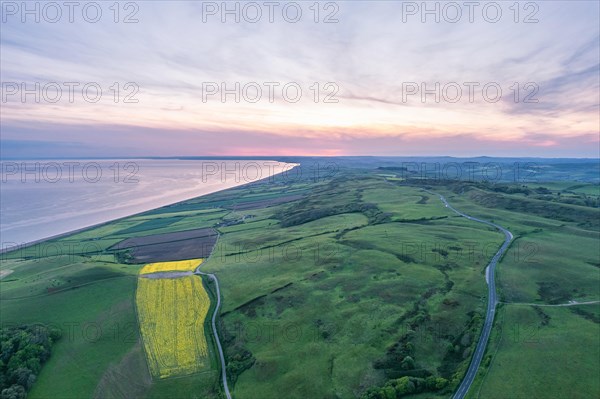 Sunset over Rapeseed field and Farmlands from a drone