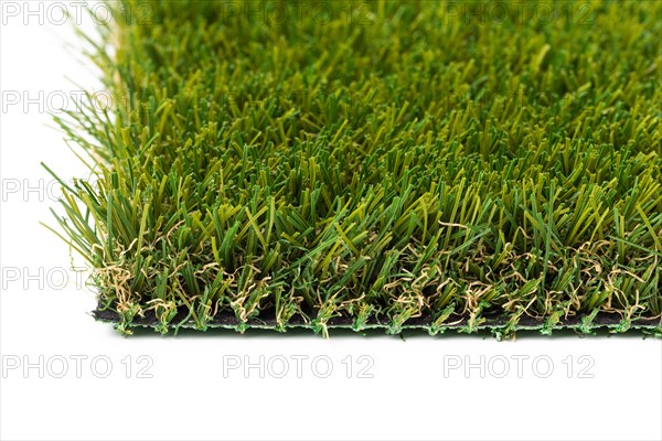 Section of artificial turf grass on white background