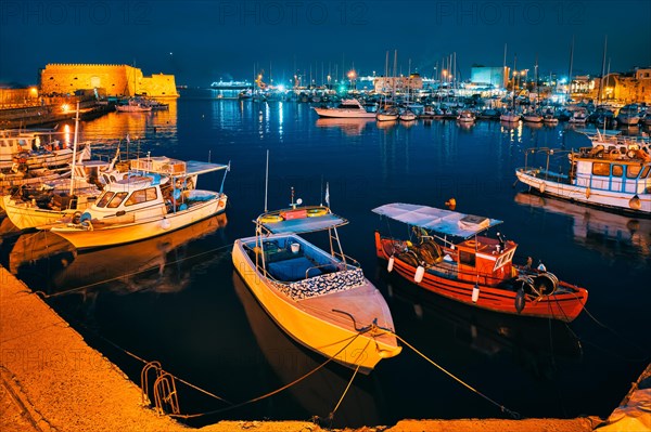 Venetian Fort castle in Heraklion and moored Greek fishing boats in port