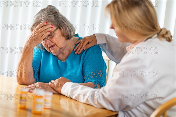 Female doctor consoling distraught senior adult woman