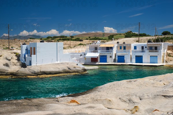 The beach of Agios Konstantinos with crystal clear turquoise water and traditional greek white houses. Milos island