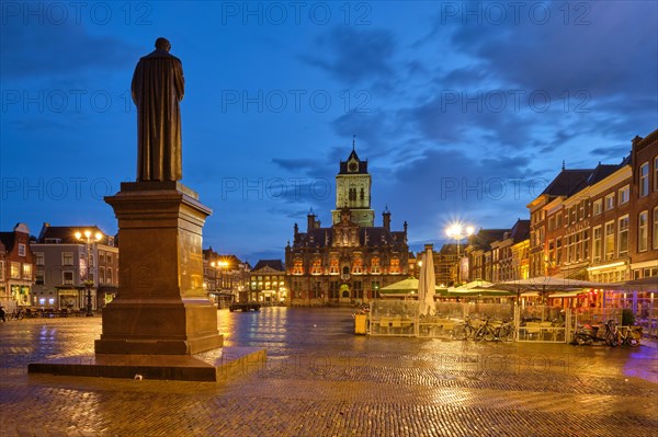 Delft City Hall and Delft Market Square Markt with Hugo de Groot Monument in the evening. Delft