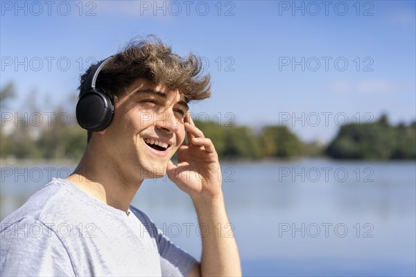 Young man listening to music outdoors with headphones. Expression of happiness