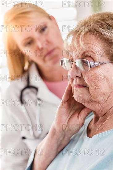 Melancholy senior adult woman being consoled by female doctor or nurse
